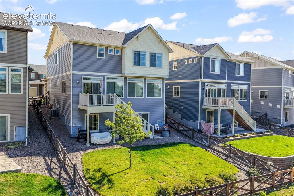Image 45 of 48: Rear exterior featuring blue siding, a white railing deck, sliding glass do