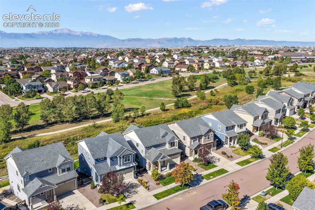 Image 48 of 48: Neighborhood setting featuring an open green space, paved street, and resid