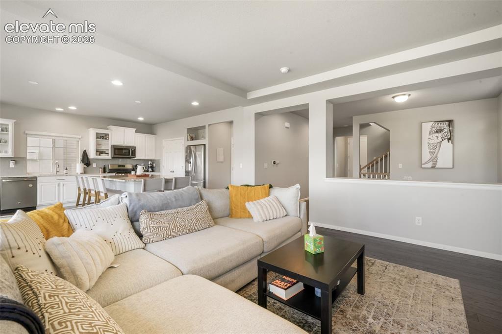 Image 5 of 48: Open-concept living space with dark wood-finish flooring, recessed lighting