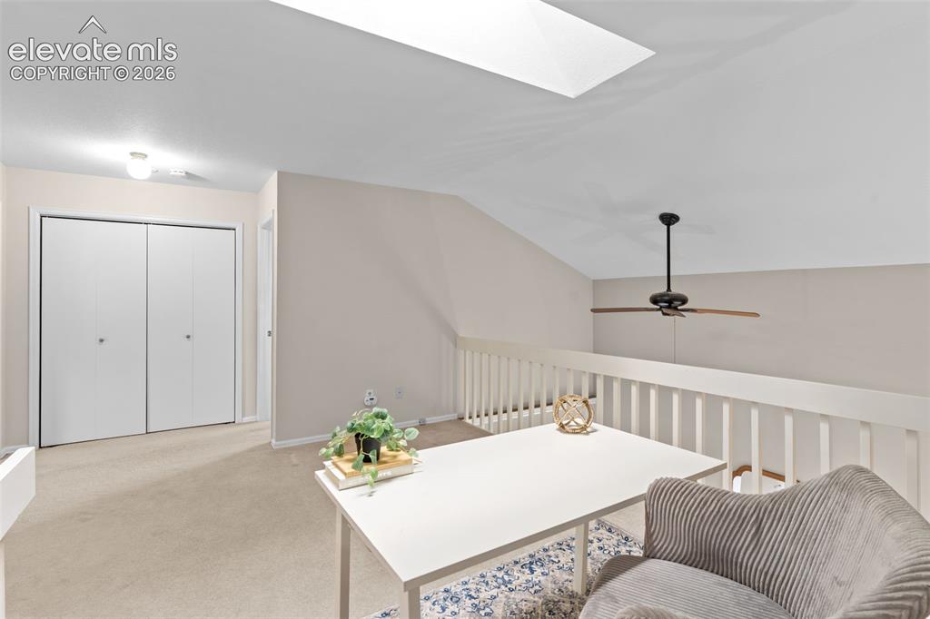 Image 17 of 32: Loft area featuring a skylight, sloped ceiling, and ceiling fan