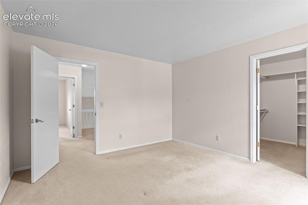 Image 19 of 32: Bedroom featuring light neutral wall paint, white trim, and light-colored c