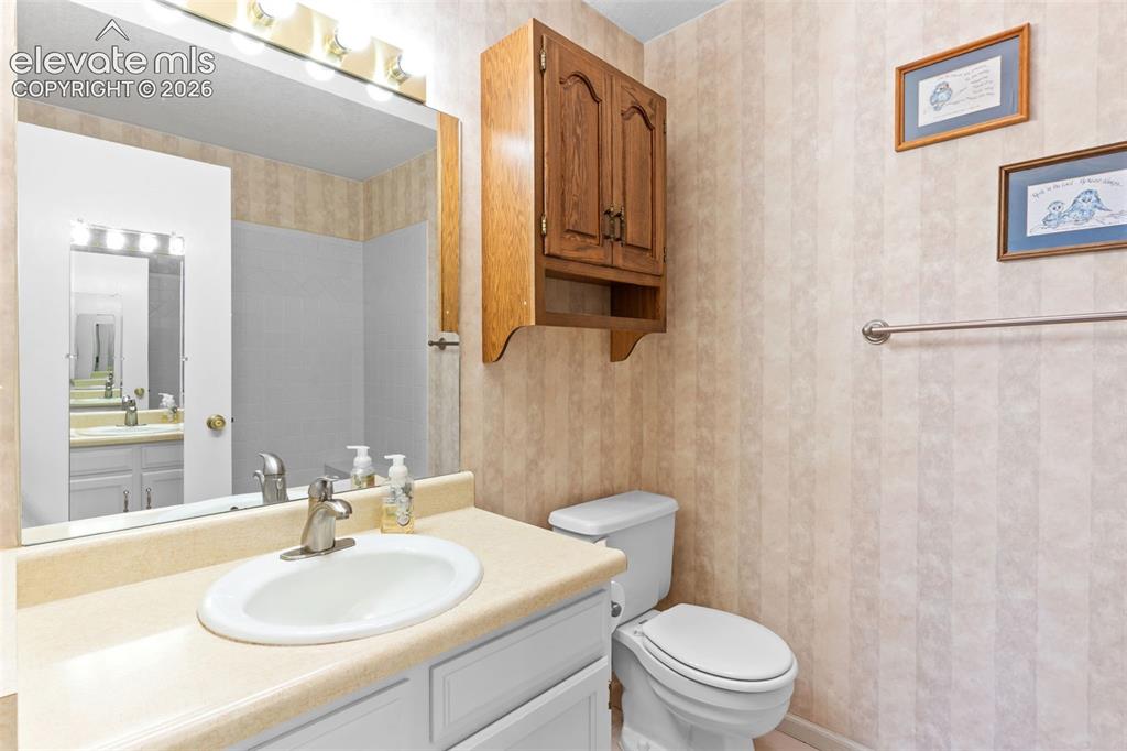 Image 20 of 32: Bathroom vanity featuring an oval undermount sink, laminate countertop, and
