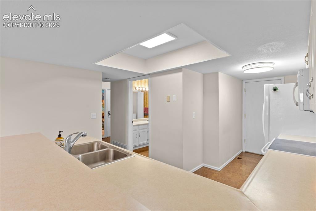 Image 22 of 32: Kitchen featuring a double stainless steel sink with a high-arc faucet, lig