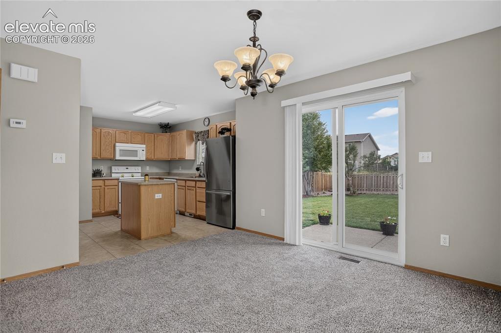 Image 10 of 36: Kitchen with wood cabinetry and stainless steel appliances