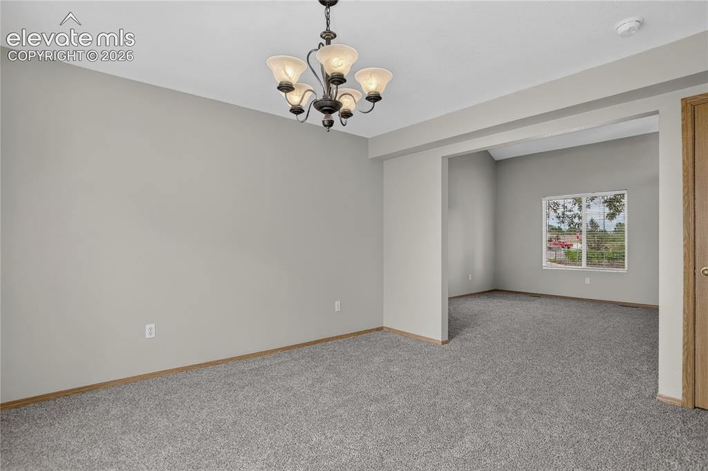 Image 11 of 36: Recessed ceiling with an ornate chandelier, neutral tone walls, and gray ca