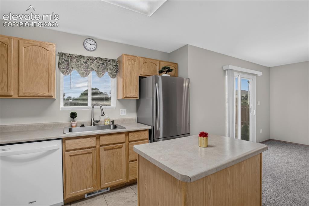 Image 14 of 36: Kitchen featuring natural wood-finish cabinetry, stainless steel refrigerat