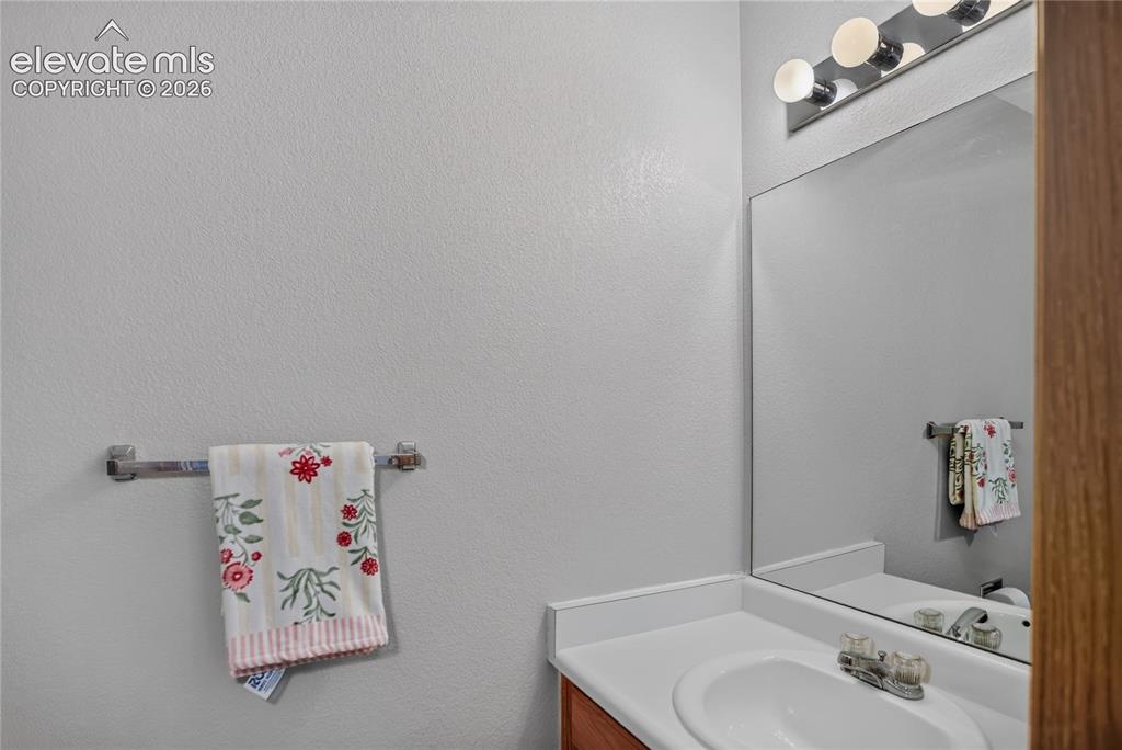 Image 18 of 36: Vanity with an integrated sink, polished chrome faucet, and a wall-mounted