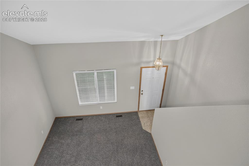 Image 19 of 36: Vaulted ceiling with an overhead light fixture, light gray walls, and dark