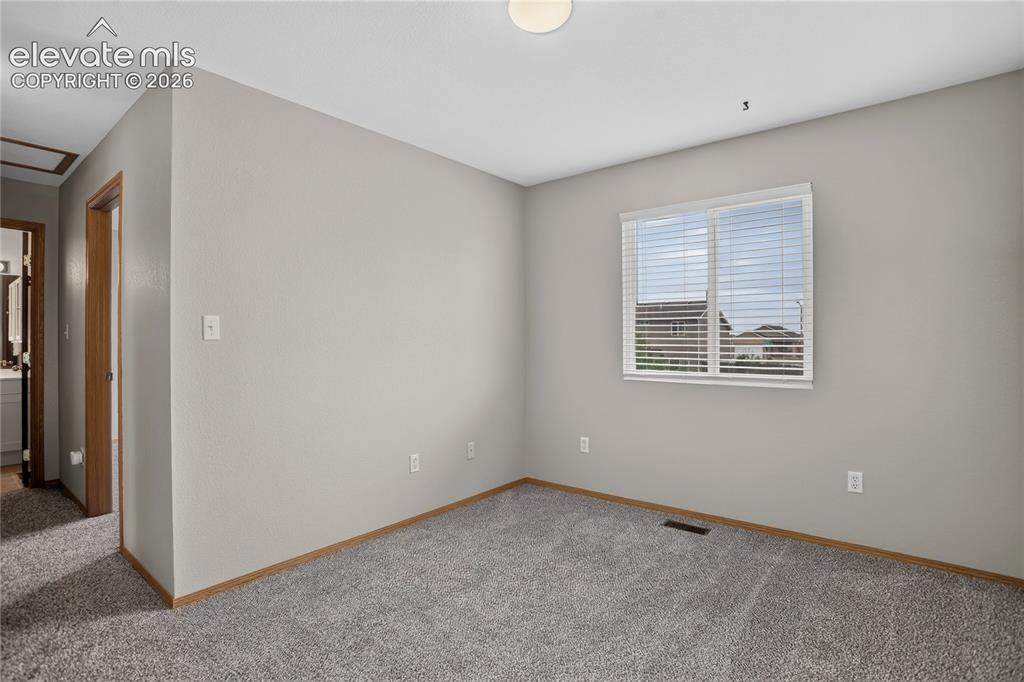 Image 22 of 36: Carpeted room with a window, white blinds, and light-colored walls