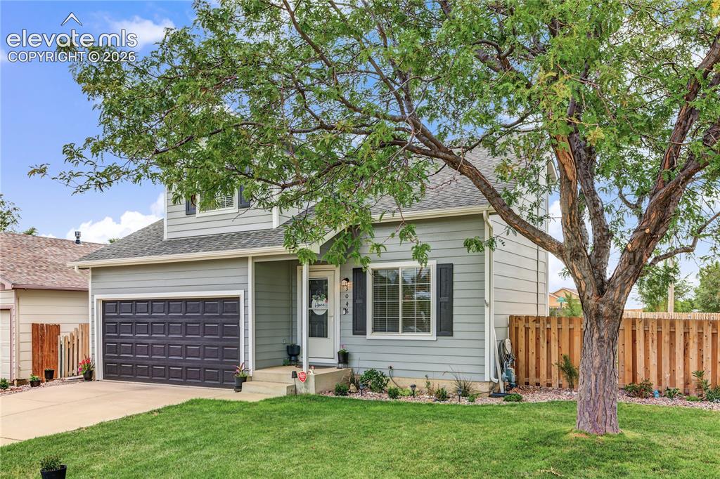 Image 3 of 36: Light gray siding exterior with a dark gray garage door, concrete driveway,