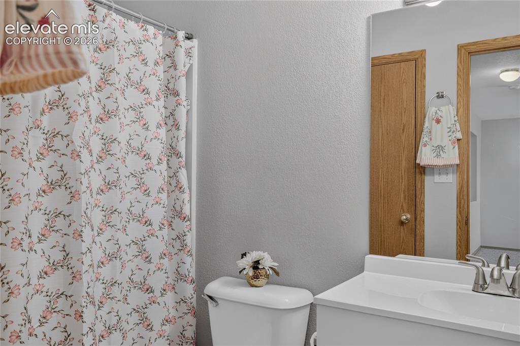Image 31 of 36: White vanity with integrated sink and chrome faucet
