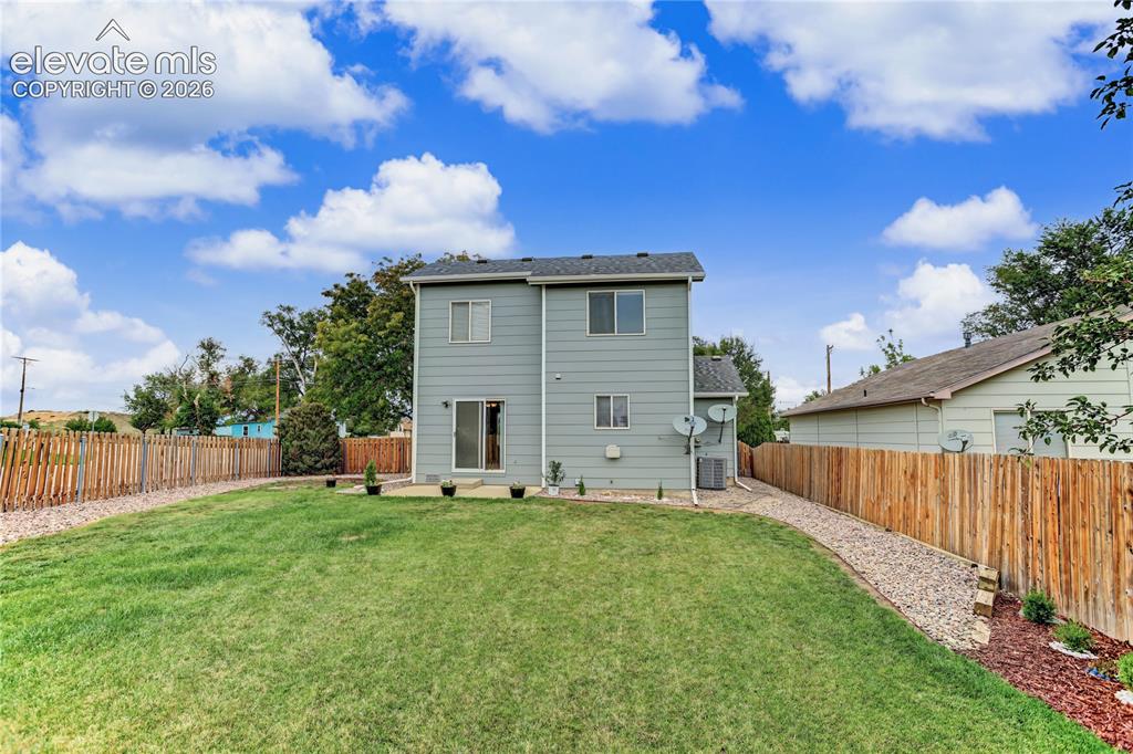 Image 34 of 36: Expansive grass lawn with a full wooden privacy fence