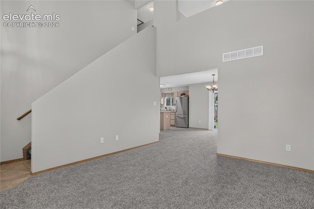 Image 6 of 36: Vaulted ceiling with recessed lighting, light gray wall finishes, gray carp