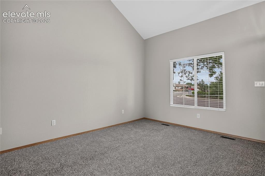 Image 7 of 36: Vaulted ceiling with neutral wall paint and grey carpeting