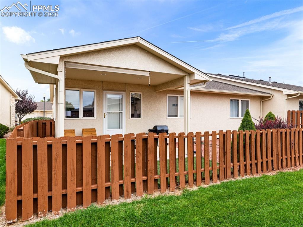 Image 2 of 25: The back yard is turf and rock with a covered back patio to enjoy all year
