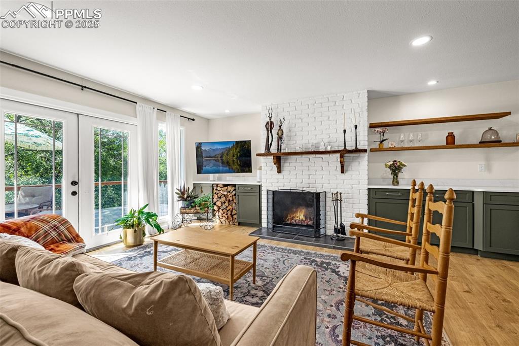 Image 11 of 43: Living area featuring a brick fireplace, recessed lighting, light wood-type