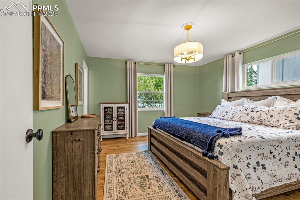 Image 14 of 43: Bedroom featuring wood finished floors and multiple windows