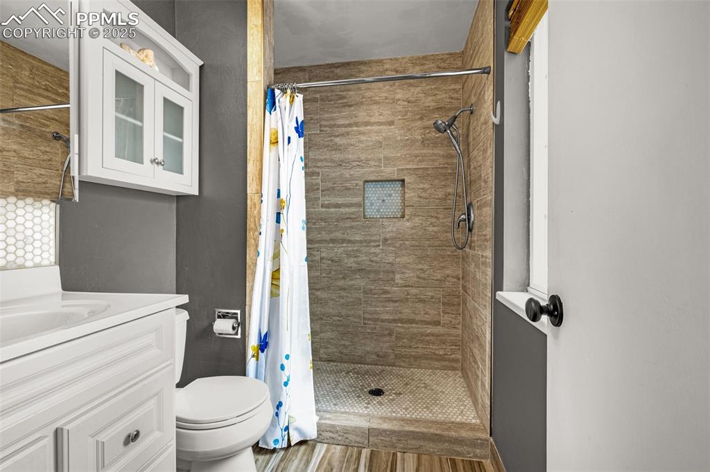 Image 15 of 43: Bathroom featuring vanity, a shower stall, and wood finished floors