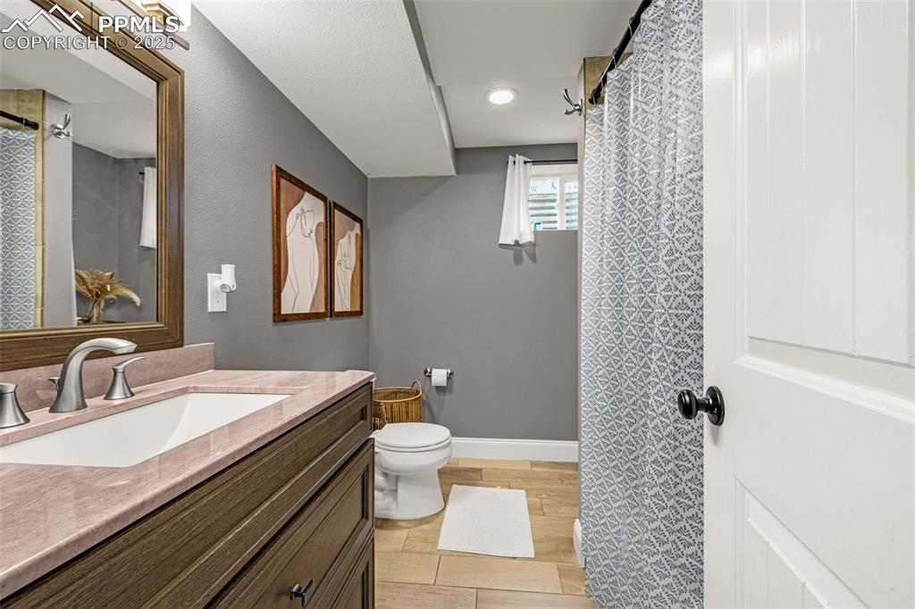 Image 16 of 43: Bathroom with vanity, light wood finished floors, recessed lighting, and a