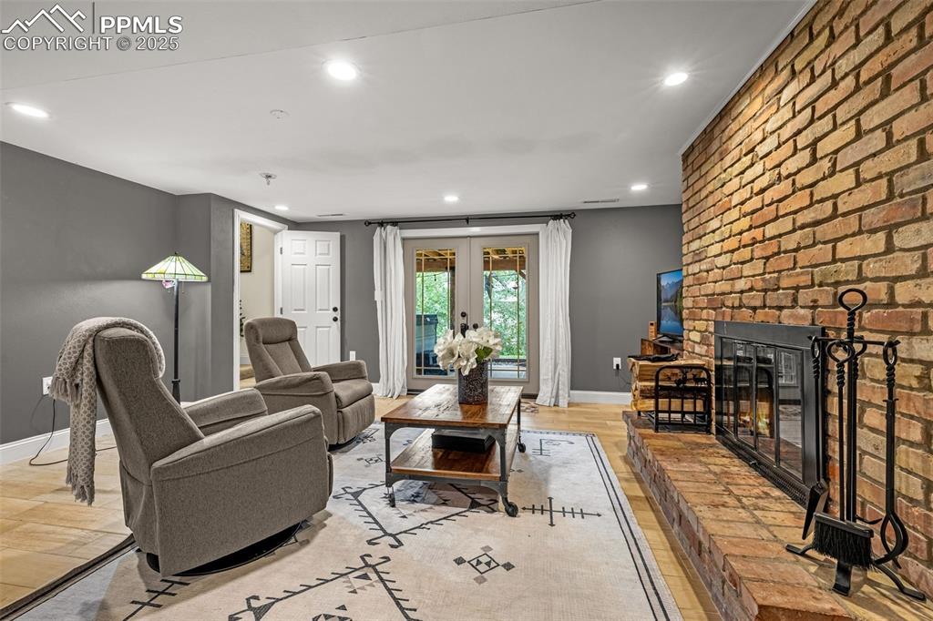 Image 18 of 43: Living room with recessed lighting, light wood finished floors, a fireplace