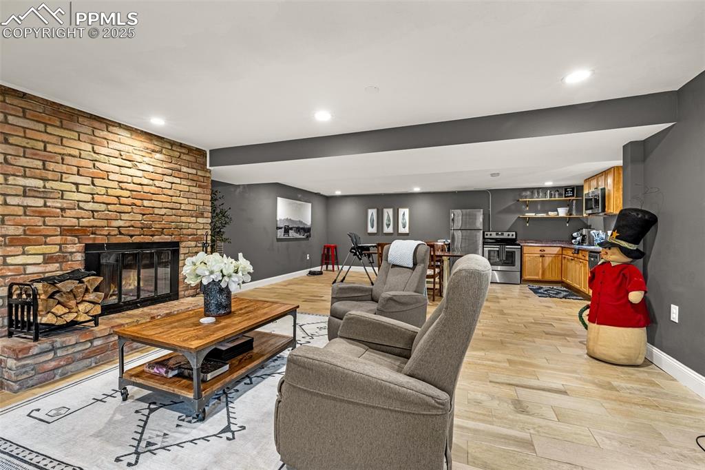 Image 19 of 43: Living room with a fireplace, recessed lighting, light wood-style flooring,