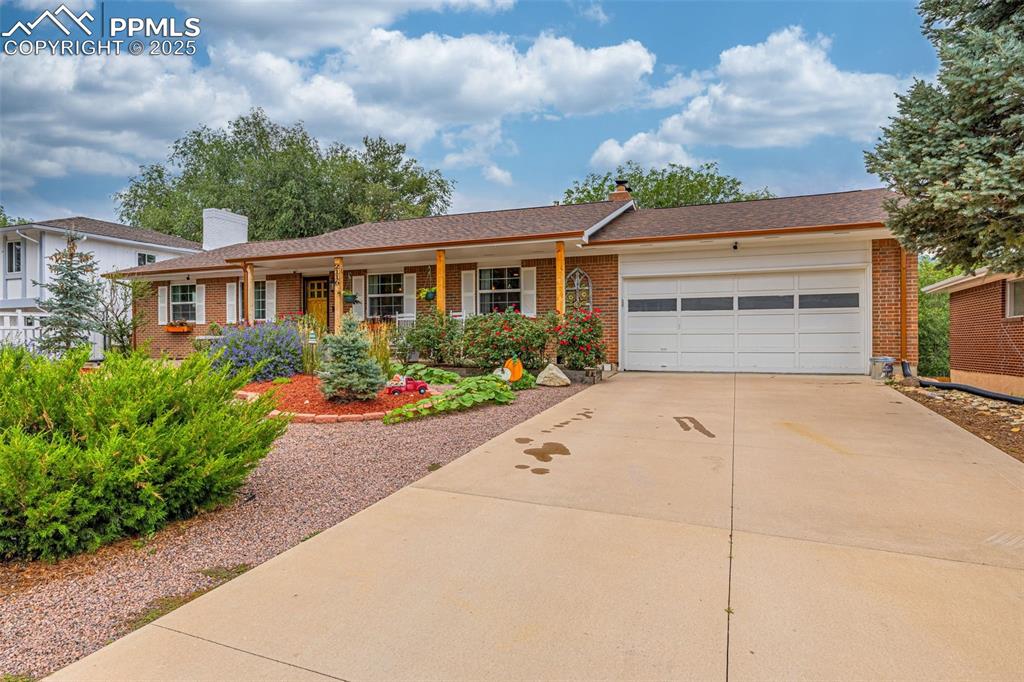 Image 2 of 43: Single story home with a chimney, brick siding, driveway, and an attached g