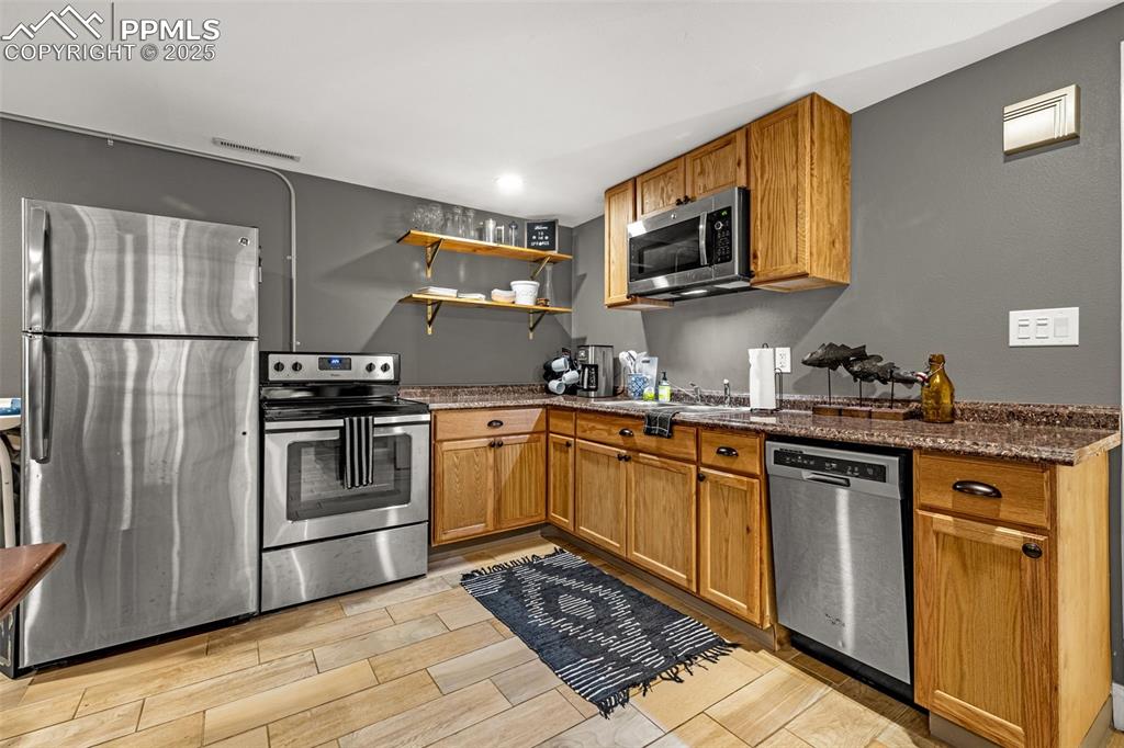 Image 21 of 43: Kitchen featuring open shelves, appliances with stainless steel finishes, b