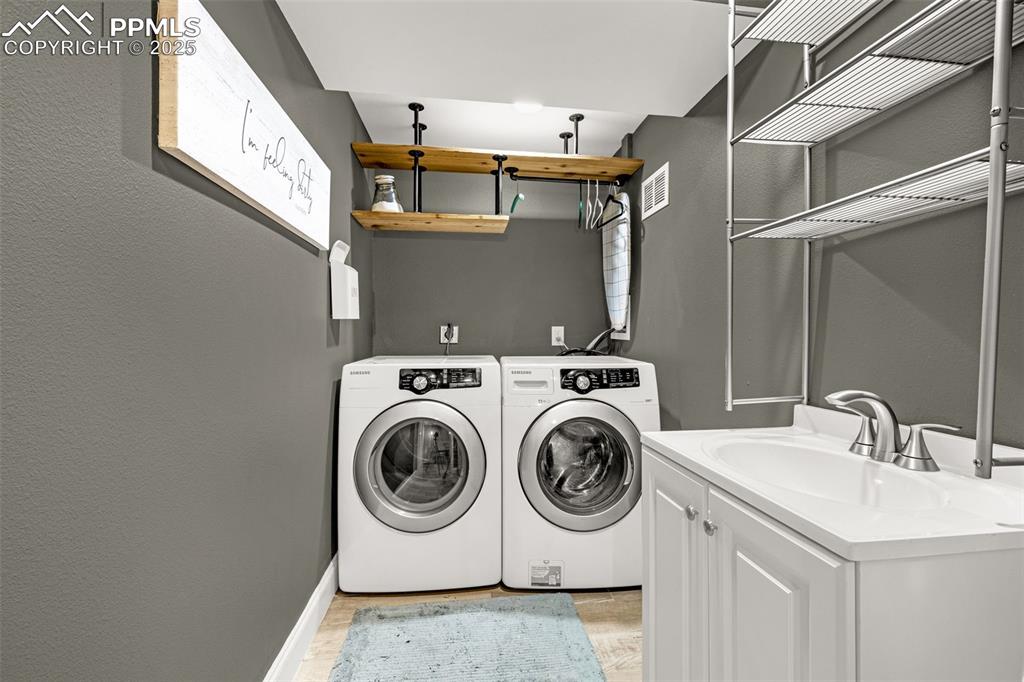Image 23 of 43: Washroom featuring washing machine and clothes dryer, light wood-style floo