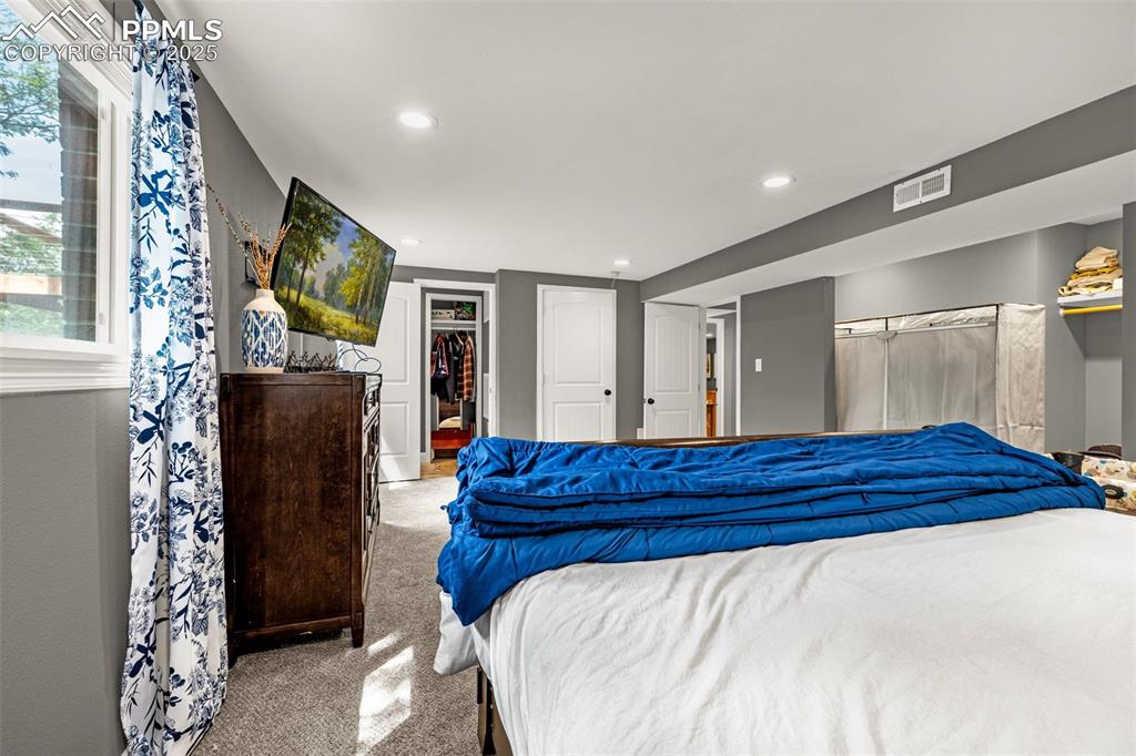 Image 24 of 43: Carpeted bedroom with recessed lighting and a spacious closet
