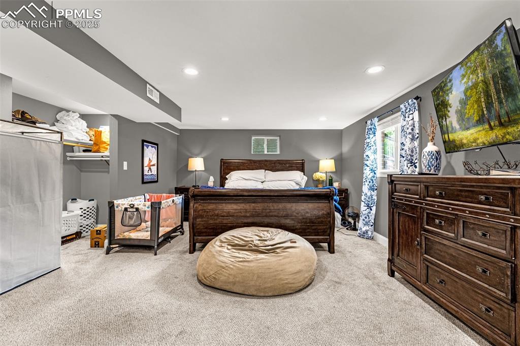Image 27 of 43: Bedroom with light colored carpet and recessed lighting
