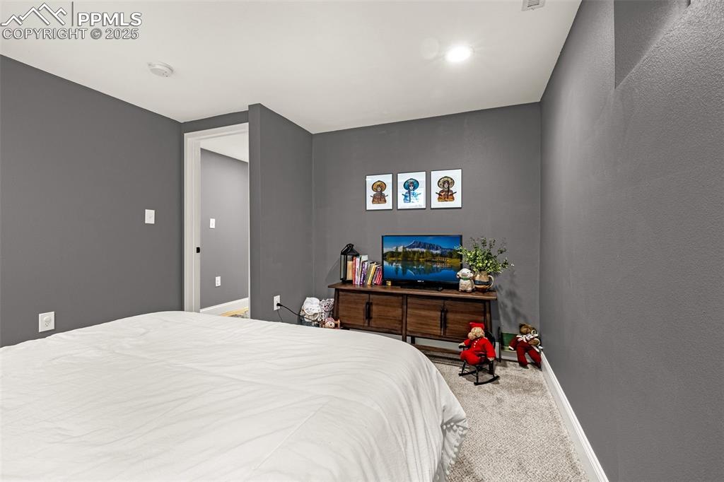 Image 28 of 43: Bedroom with carpet floors and a textured wall