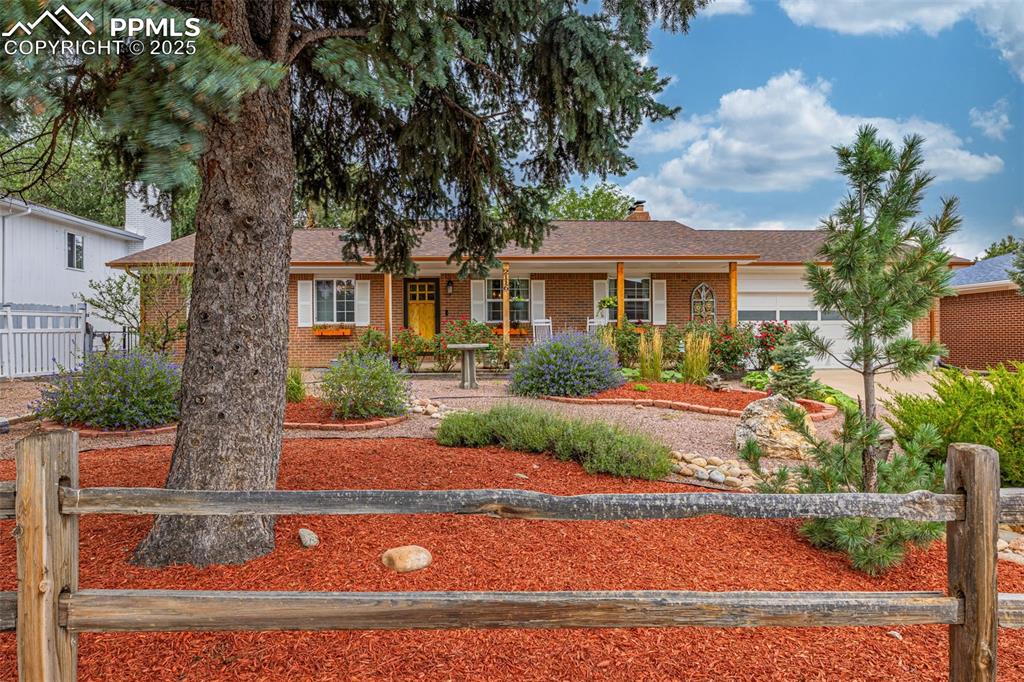 Image 3 of 43: Single story home with brick siding, a chimney, an attached garage, a porch