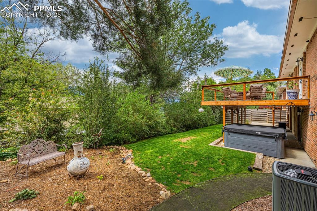 Image 36 of 43: View of grassy yard with a hot tub