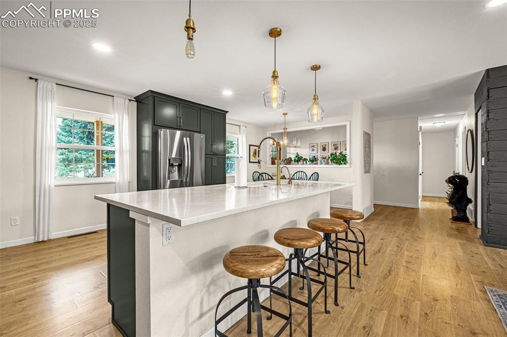 Image 6 of 43: Kitchen featuring a kitchen breakfast bar, recessed lighting, light wood-st