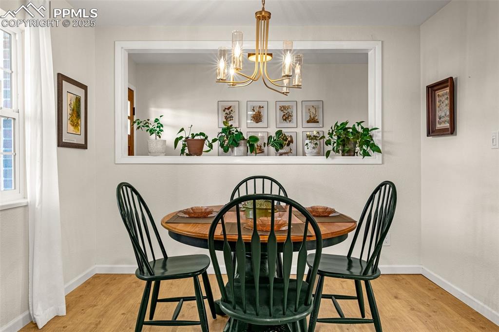 Image 8 of 43: Dining space with light wood-style flooring and a chandelier