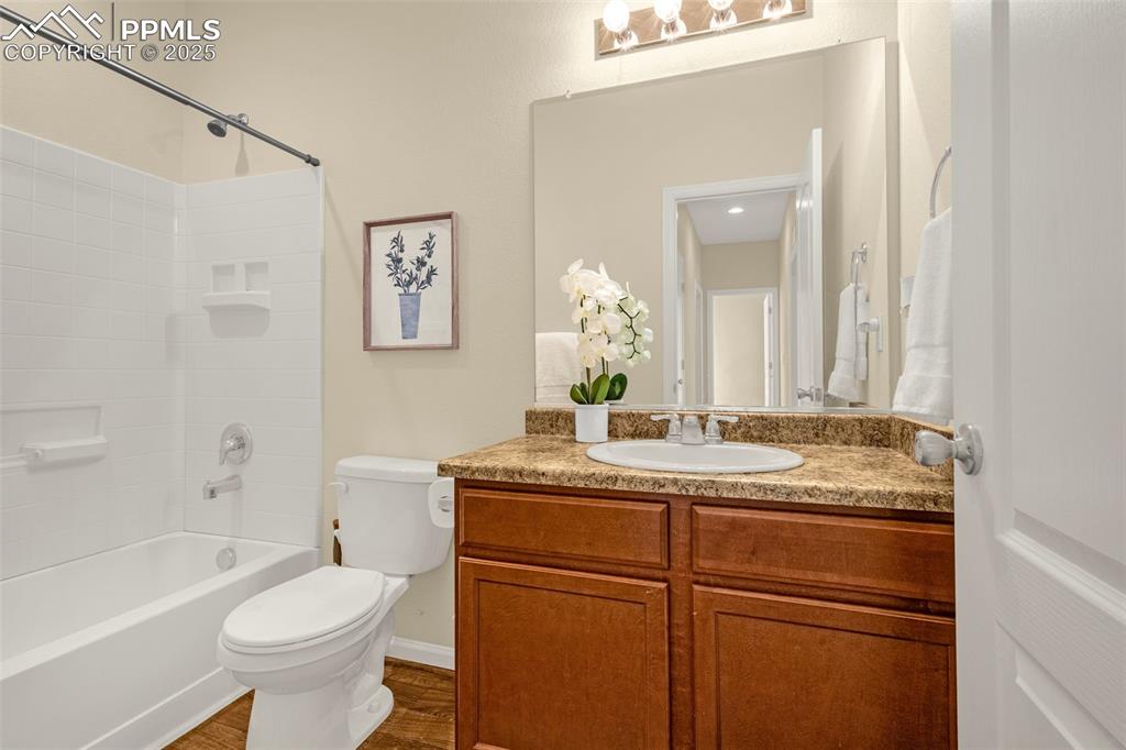 Image 10 of 28: Full bath with shower / bathtub combination, toilet, vanity, and wood finis