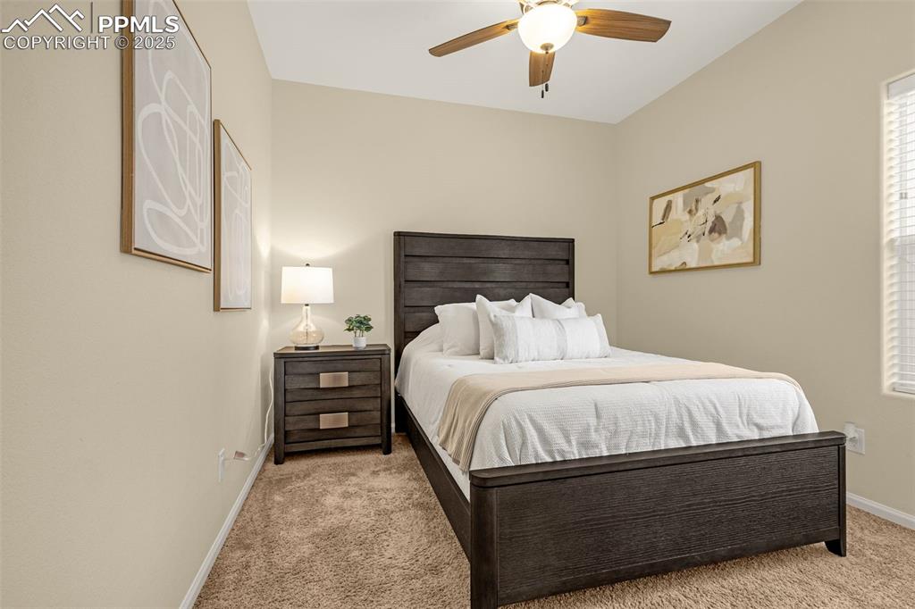 Image 12 of 28: Bedroom featuring ceiling fan, light carpet, and baseboards