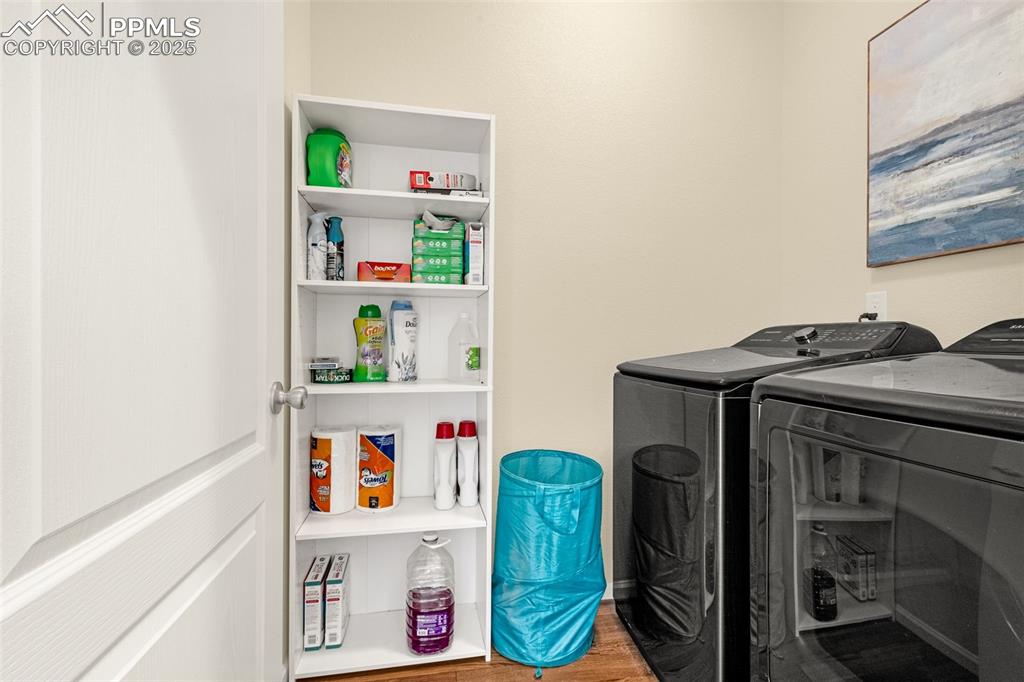 Image 18 of 28: Clothes washing area with washing machine and dryer, wood finished floors, 