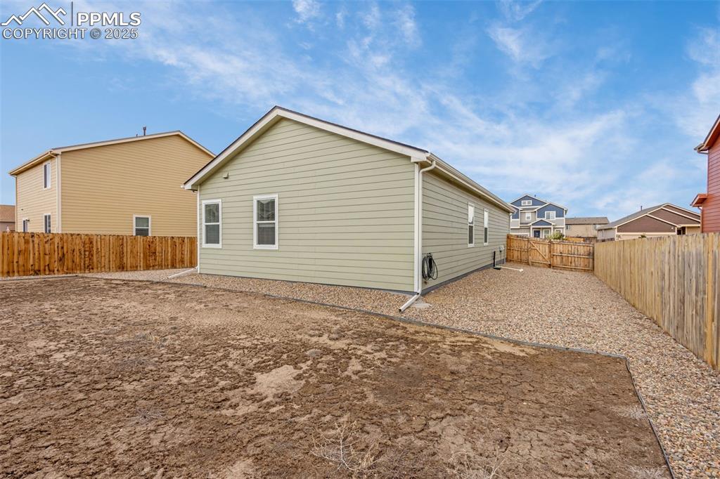 Image 19 of 28: Rear view of house featuring a fenced backyard
