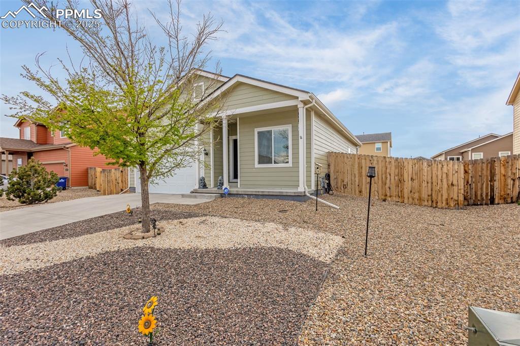 Image 2 of 28: View of front of home with an attached garage, driveway, and fence
