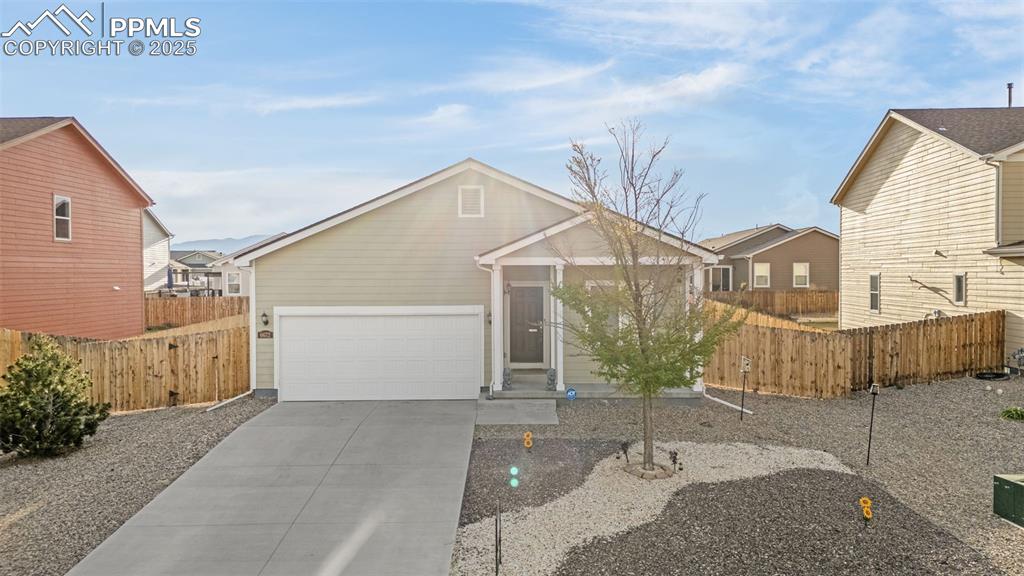 Image 22 of 28: View of front of property featuring an attached garage, driveway, and fence