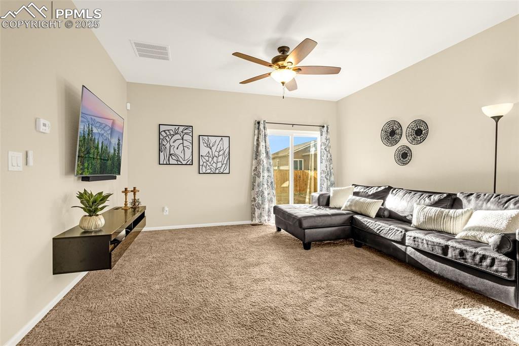 Image 4 of 28: Living room featuring carpet, visible vents, a ceiling fan, and baseboards