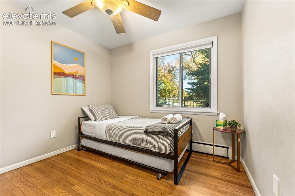 Image 17 of 39: Bedroom featuring a baseboard heating unit, light wood-style floors, and ce