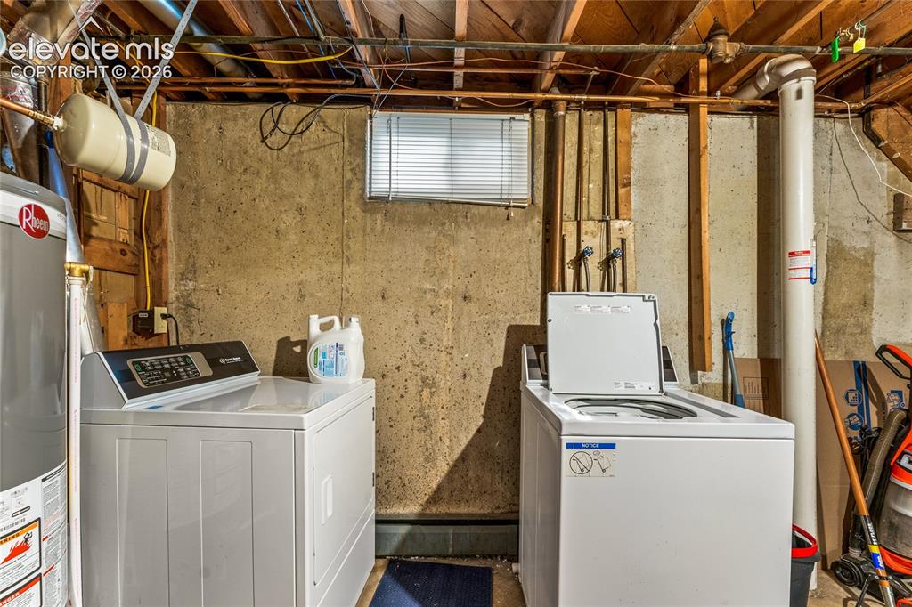 Image 30 of 39: Laundry area with water heater and separate washer and dryer