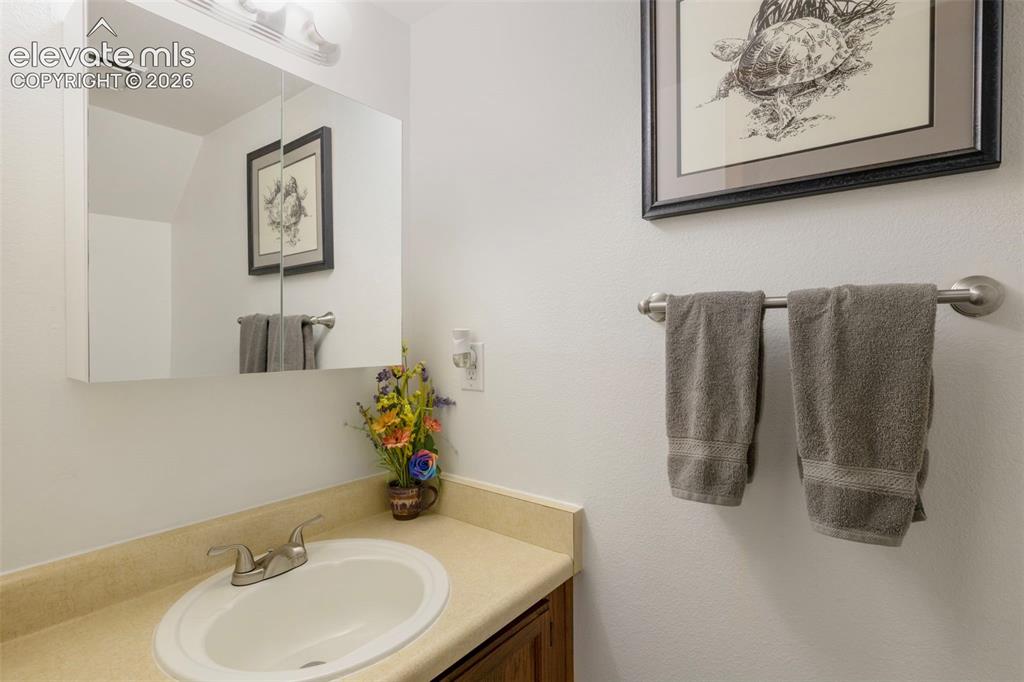 Image 13 of 26: Bathroom featuring a white oval undermount sink, a chrome two-handle faucet