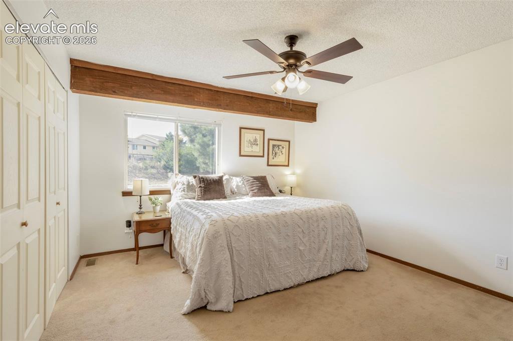 Image 16 of 26: Carpeted room featuring a ceiling fan with integrated lighting, a broad win