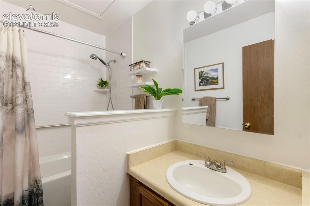 Image 21 of 26: Bathroom featuring a vanity with an integrated sink, a large wall-mounted m