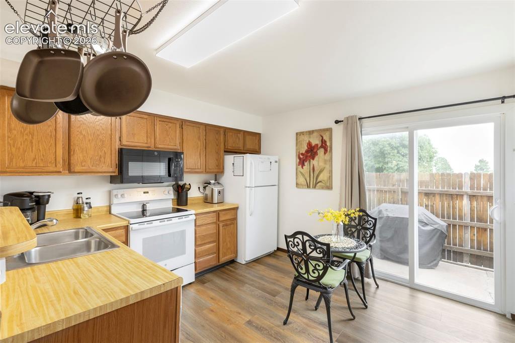 Image 8 of 26: Kitchen featuring wood cabinetry, laminate countertops, a double basin stai