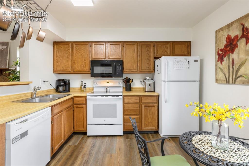 Image 9 of 26: Functional kitchen featuring wood-finish cabinetry and light-toned countert