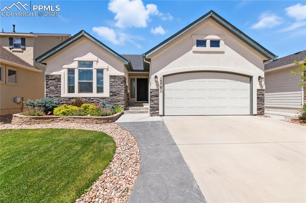Image 1 of 40: View of front facade featuring driveway, stucco siding, an attached garage,